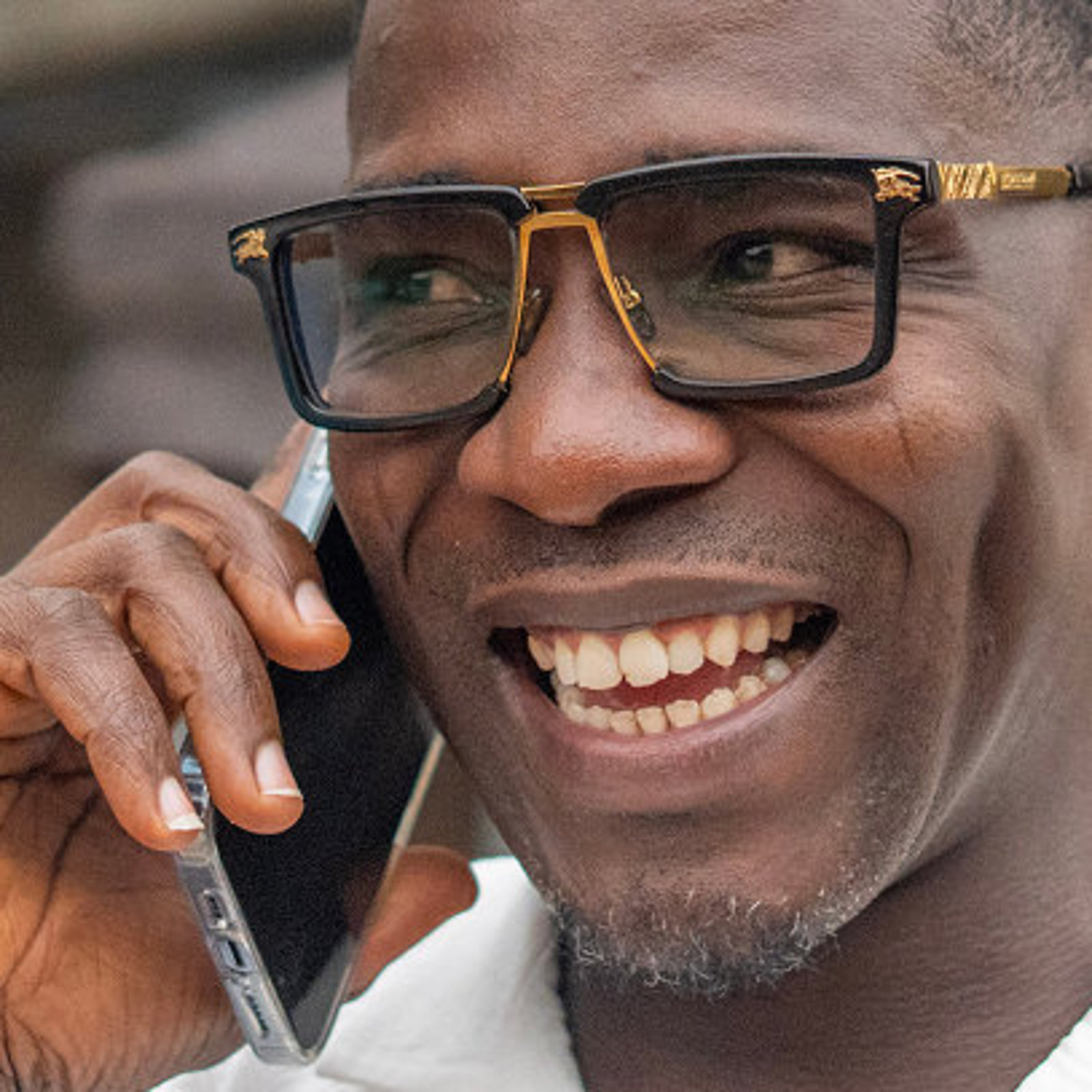 Nonso, ein Teilnehmer des ARRIVES-Programms, lächelt, während er telefoniert, nachdem er von ARRIVES Unterstützung für seine freiwillige Rückkehr nach Nigeria erhalten hat.