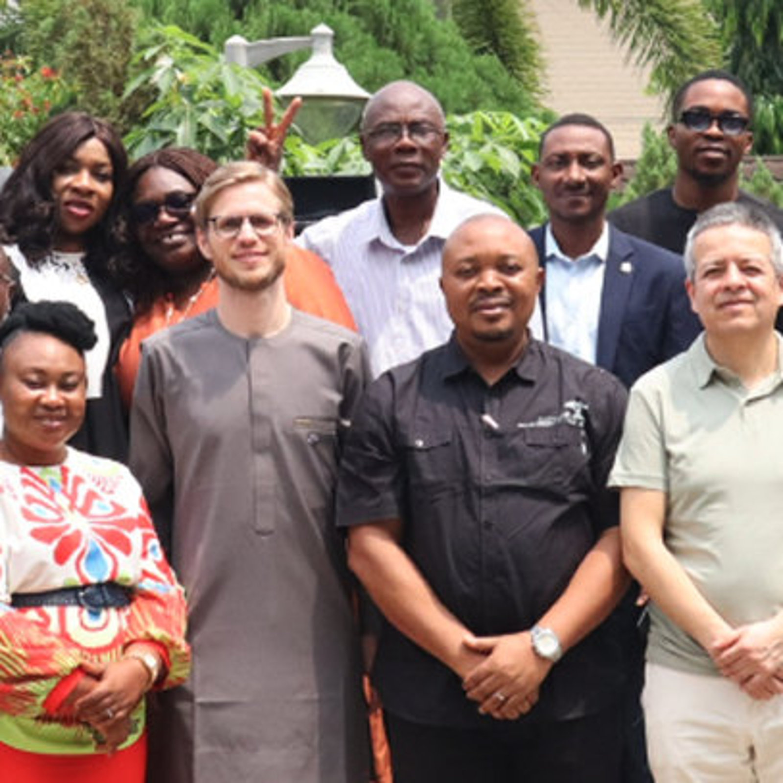 Das ARRIVES-Team in Nigeria hat sich versammelt und lächelt für ein Gruppenfoto neben einem ARRIVES-Banner.