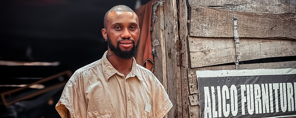 Der ARRIVES-Teilnehmer Benjamin steht vor seinem Möbelgeschäft, das er in Benin City gegründet hat, nachdem er nach einem langjährigen Aufenthalt in Deutschland zurückgekehrt war.