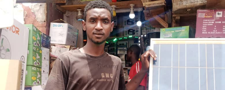 Umar steht vor seinem Solarenergieunternehmen, das er mit Unterstützung von ARRIVES in Nigeria gegründet hat, nachdem er einige Zeit in Deutschland verbracht hatte.